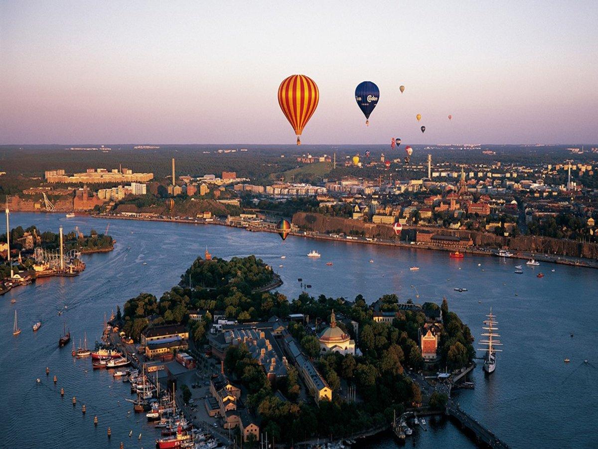 Flygbild över Skeppsholmen. I bakgrunden syns Nacka. Vi ser också flertalet färgglada luftballonger