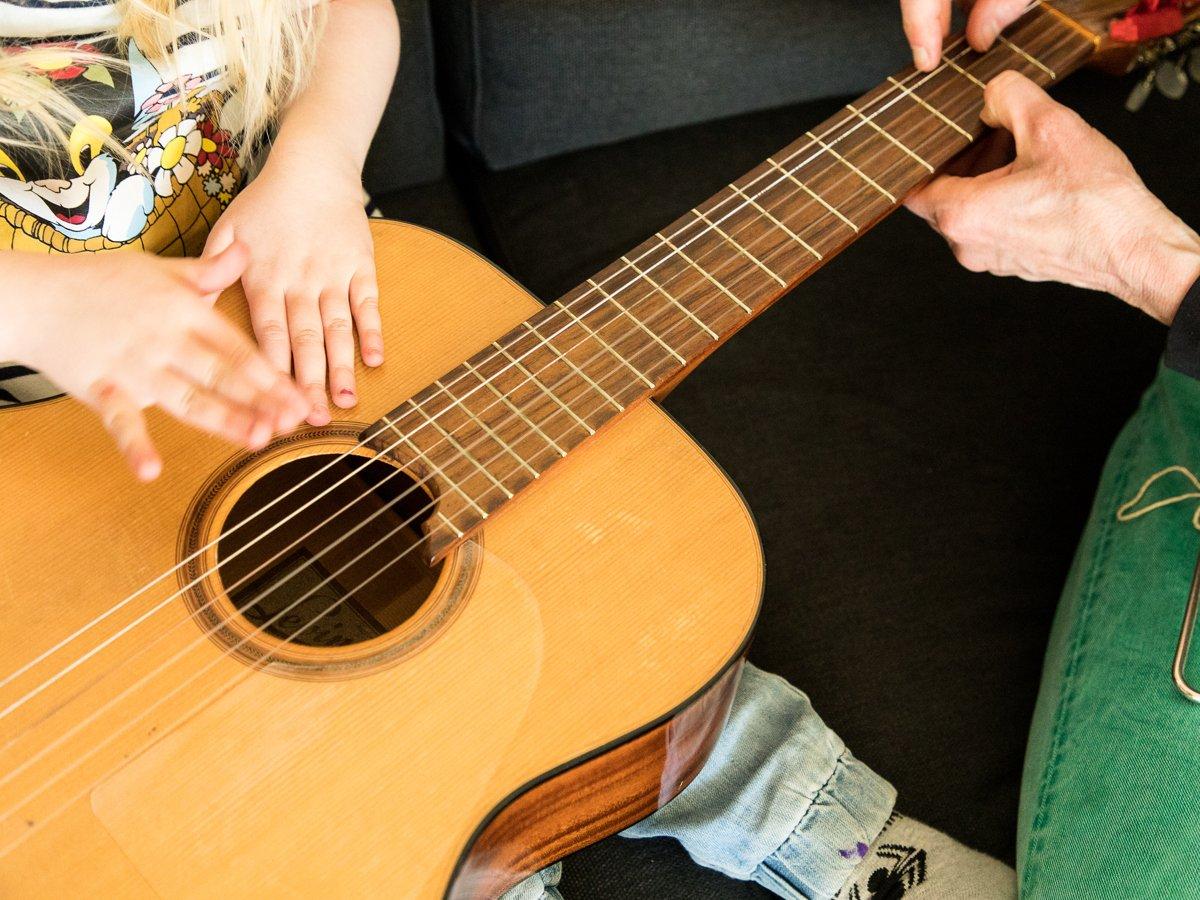 Barnhänder mot en gitarr