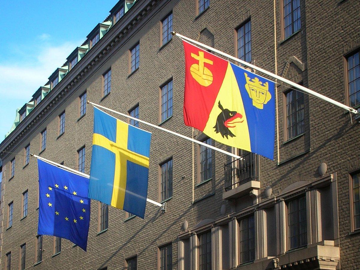 Bild på Länsstyrelsen i Stockholms husfasad med 3 st flaggor. Närmast i bild länsflaggan, i mitten svenska flaggan och EU-flaggan längst bort i bild.