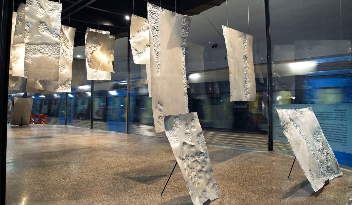 metallpl&aring;tar som h&auml;nger fr&aring;n taket i montern. Pl&aring;tarna har f&aring;tt m&ouml;nster av droppande vatten och salt.