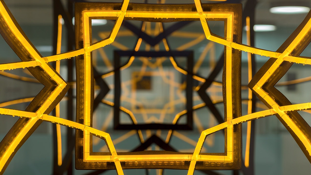 Närbild av konstverk med starkt gult ljus i formation.