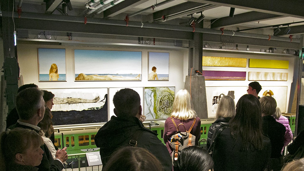 Grupp människor tittar på konsten på Spårvägsmuseet.