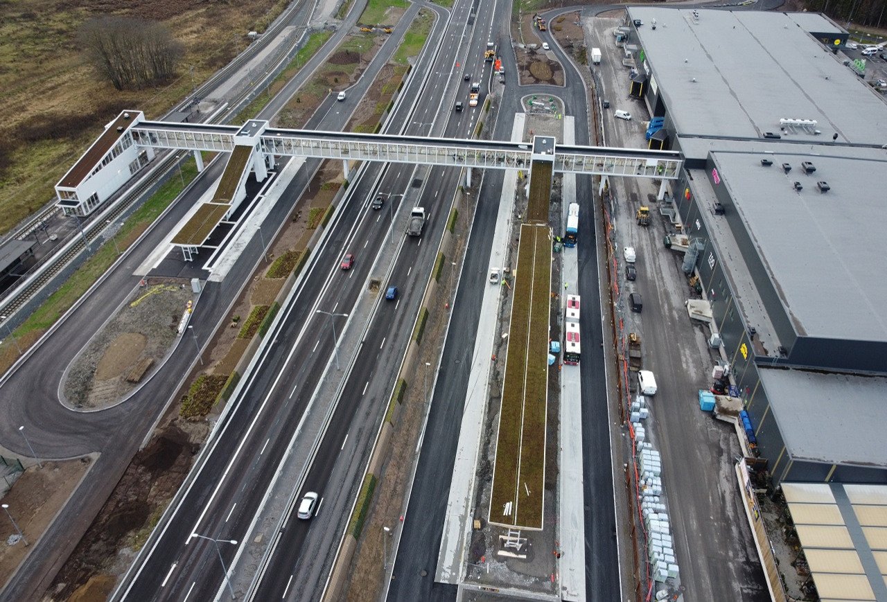 Flygbild station med gångbro över väg