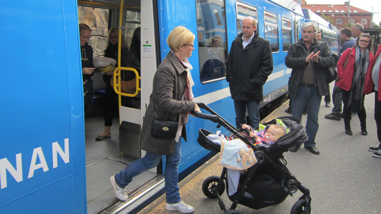 Kvinna med barnvagn går av tåget