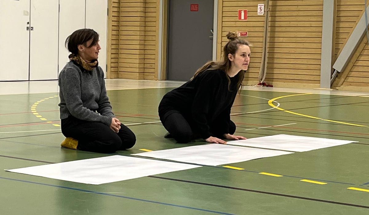 Två cirkusartister under en workshop i en idrottshall