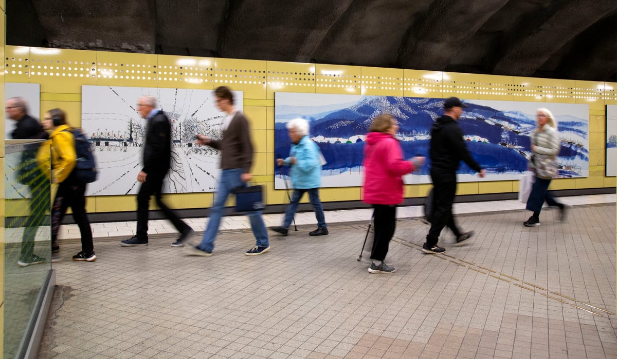 En grupp människor som går längs en tunnelbaneperrong.