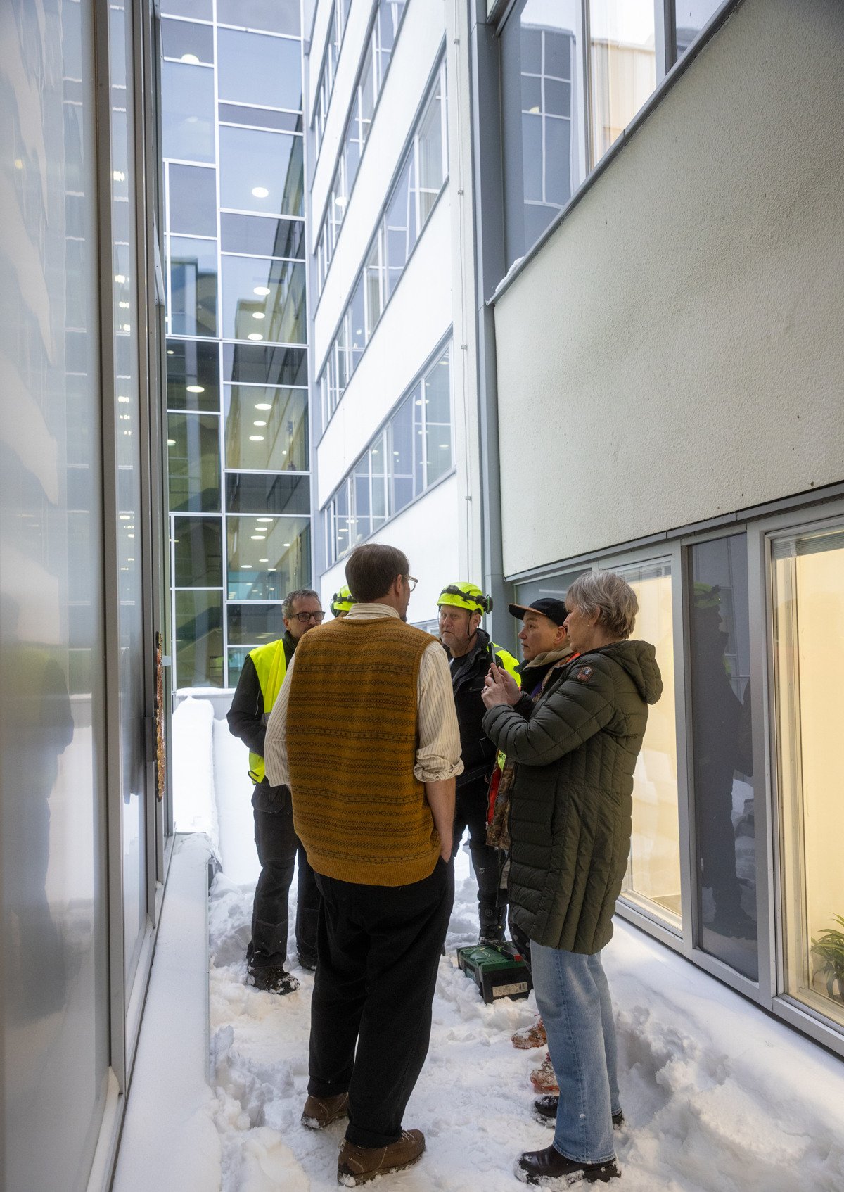 En grupp m&auml;nniskor som st&aring;r utanf&ouml;r en byggnad.