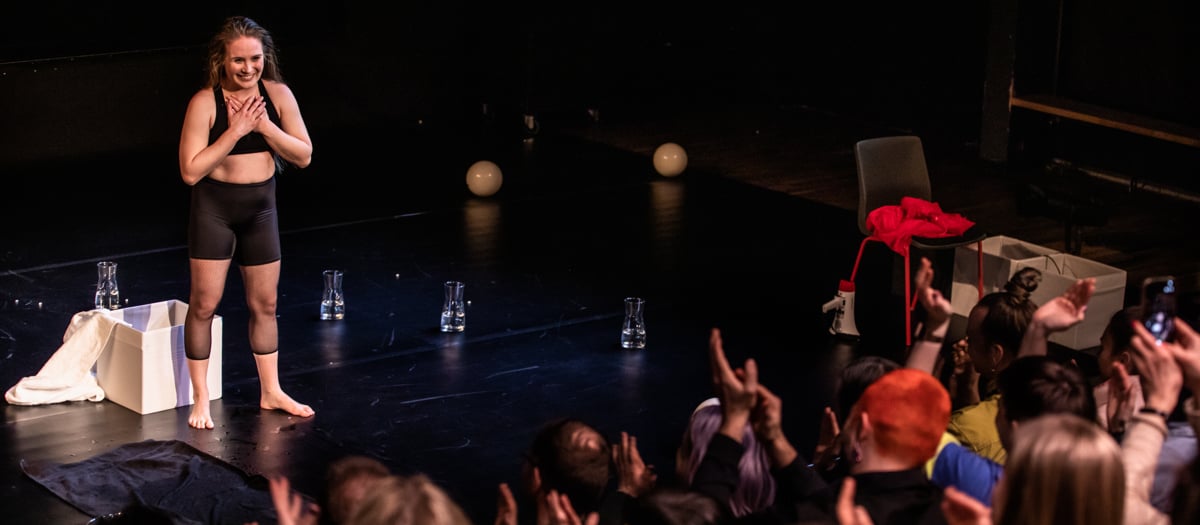 En kvinna som st&aring;r p&aring; en scen framf&ouml;r en folkmassa.