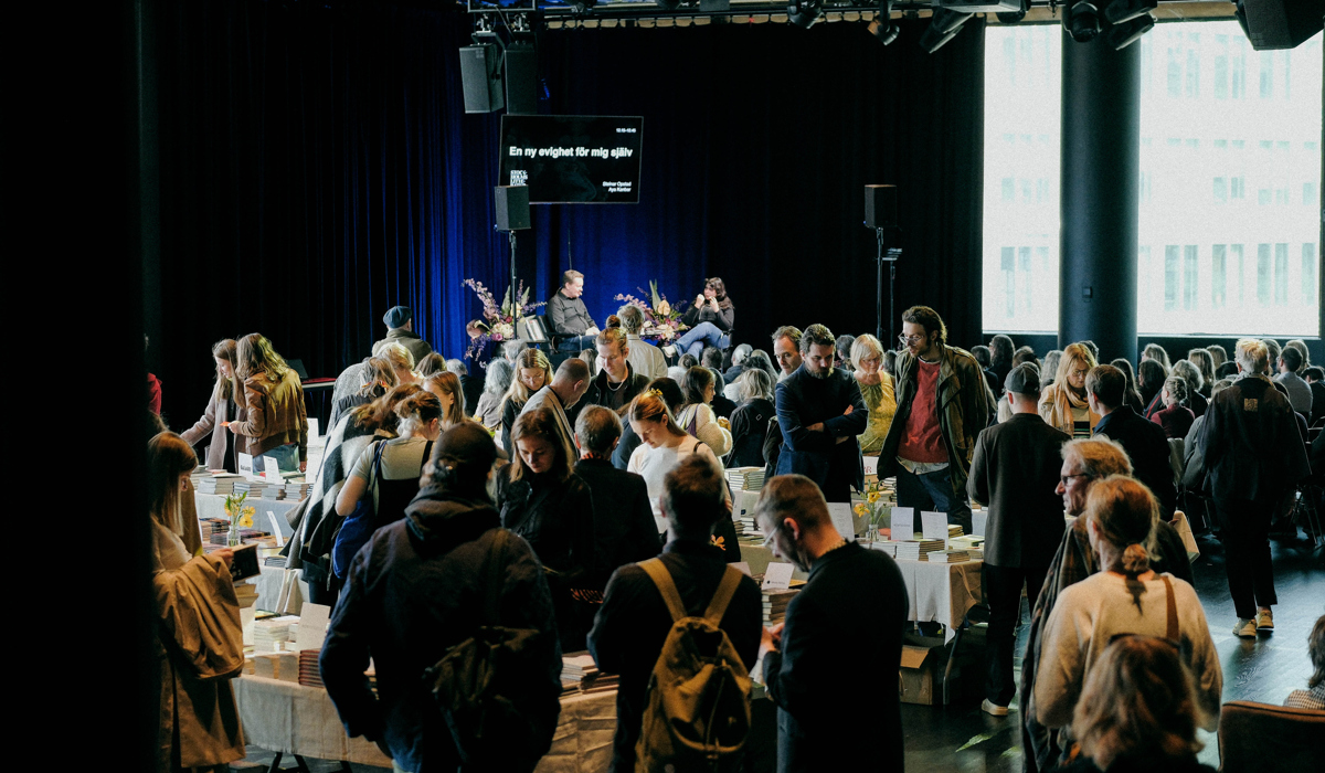 En stor grupp m&auml;nniskor som st&aring;r runt ett rum.