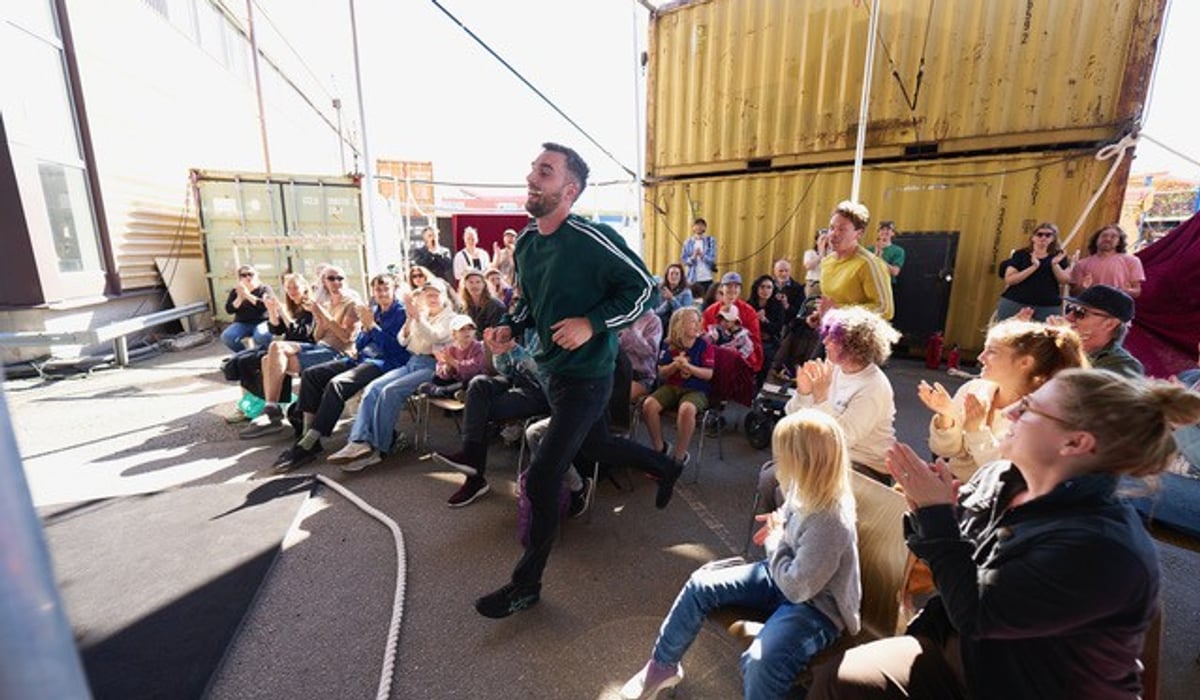 En man som springer runt bland en grupp sittande m&auml;nniskor.