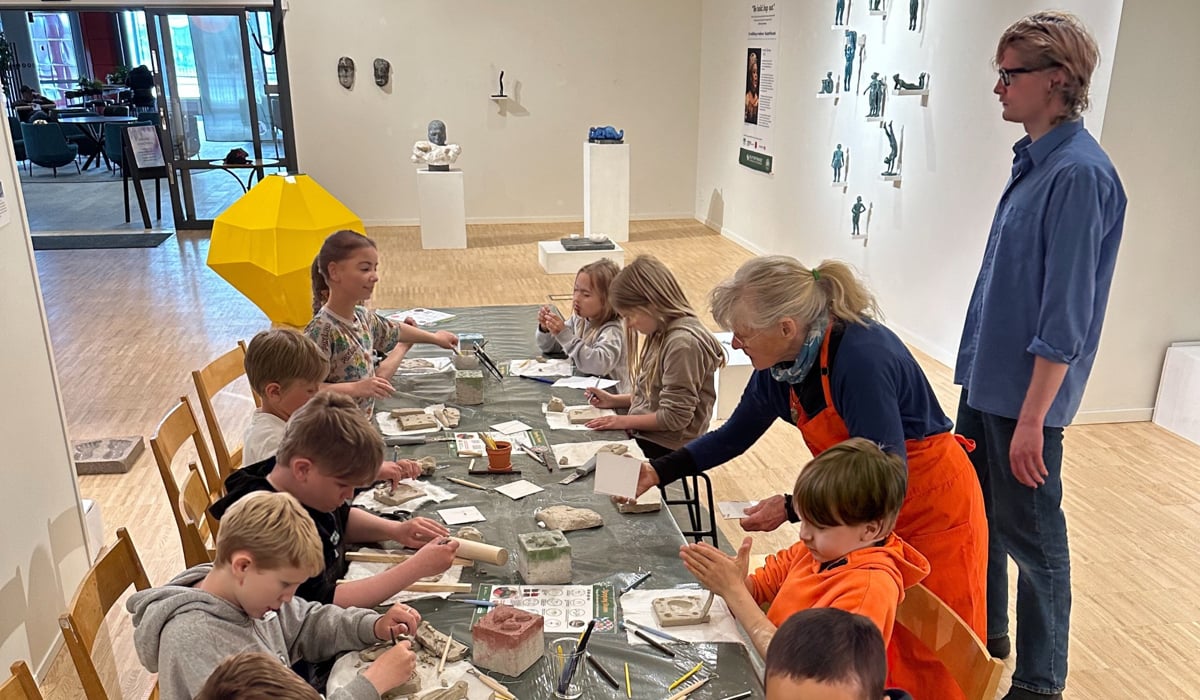 En grupp barn som sitter vid ett bord tillsammans.