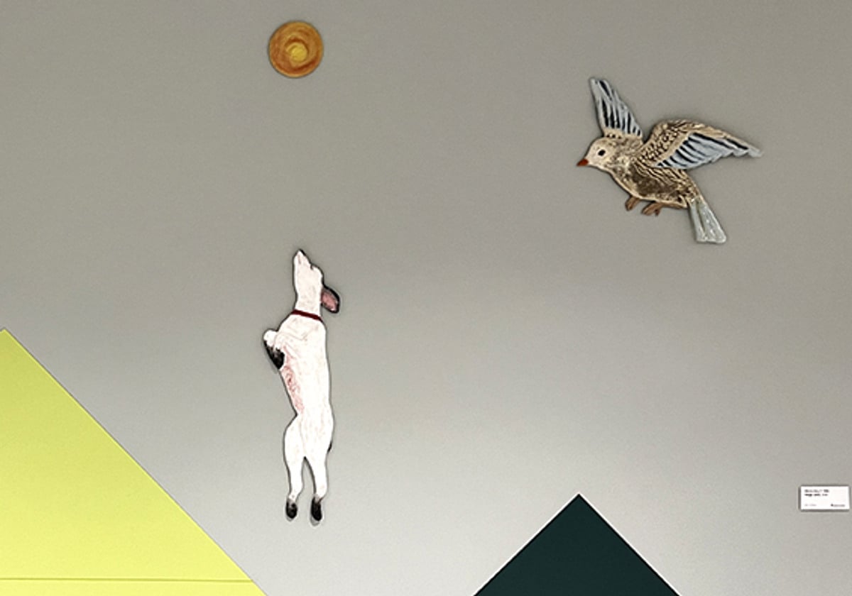 Ett rum med en hund och en f&aring;gel p&aring; v&auml;ggen.