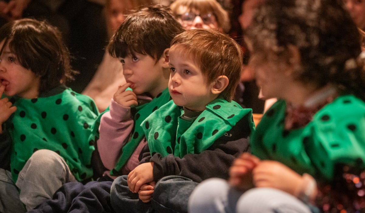 En grupp sm&aring; barn som sitter bredvid varandra.