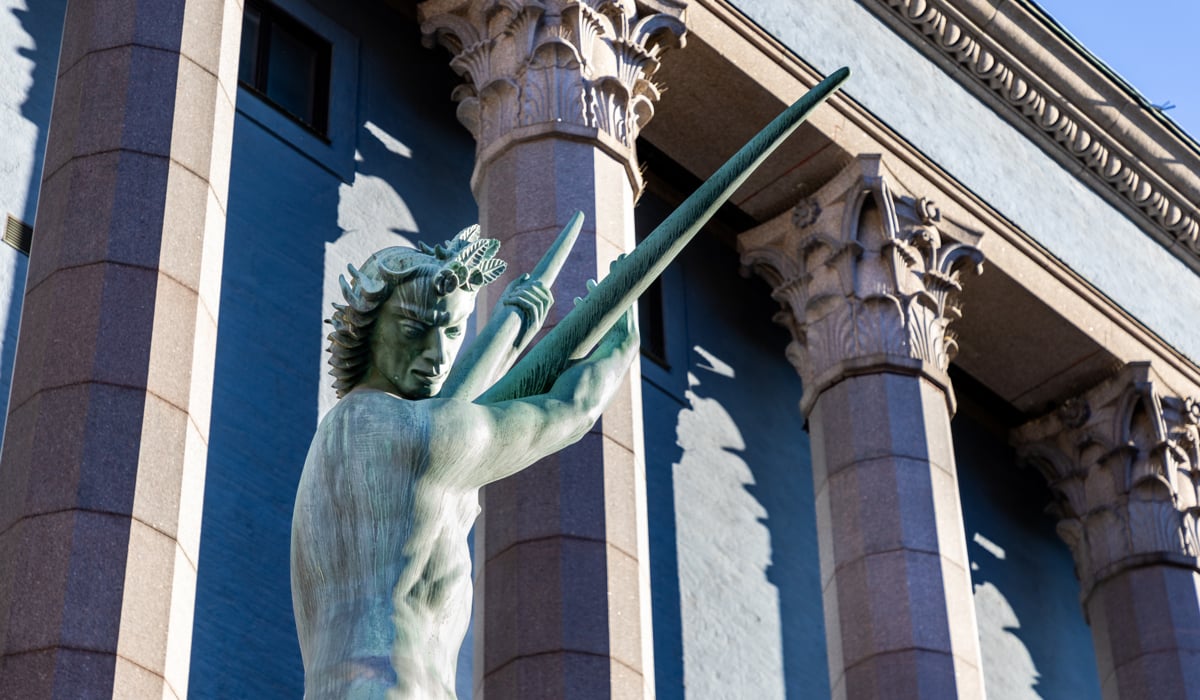En staty av en man som håller ett svärd framför Konserthuset.