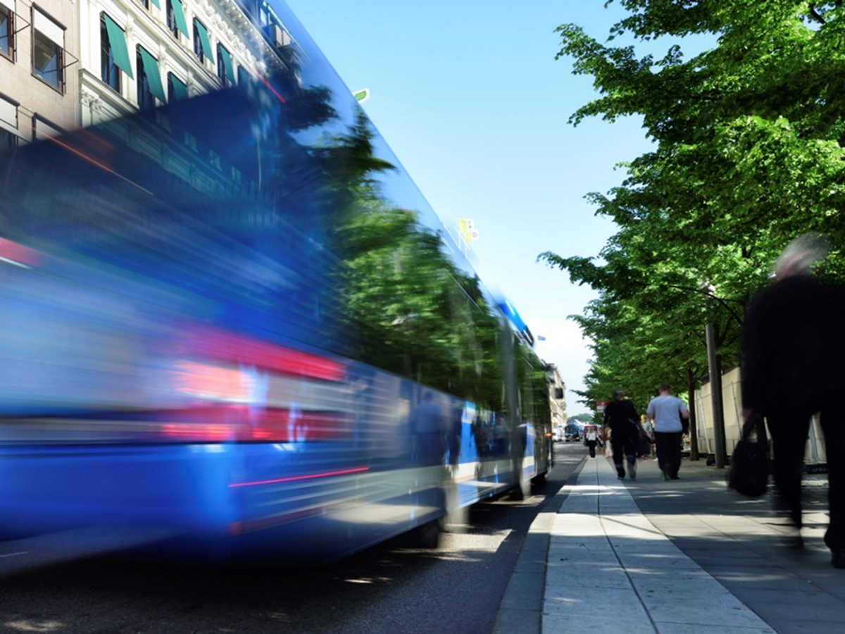 Bild på en expressbuss i trafik på en stadsgata.