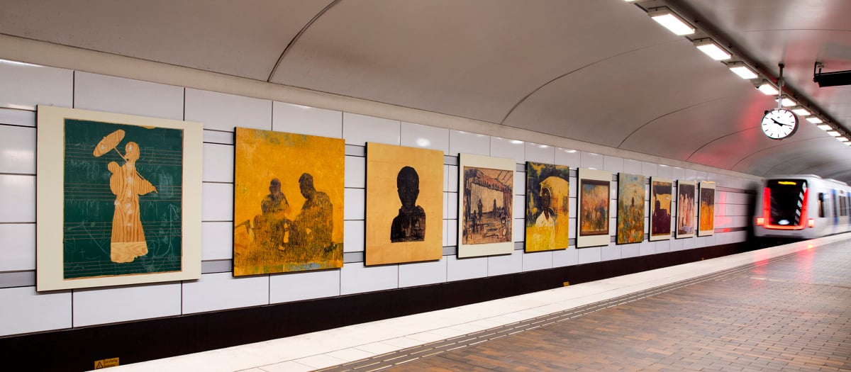 En tunnelbanestation med en massa affischer på väggen.