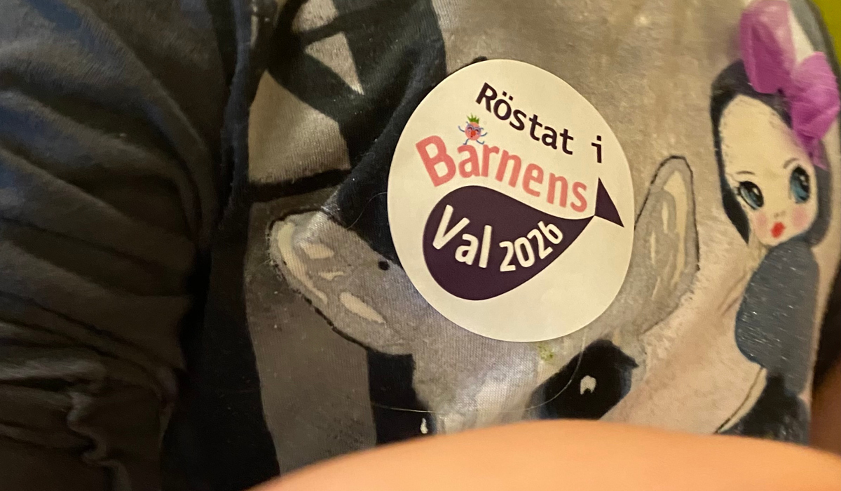 En närbild av ett barn som har en dekal på tröjan med texten Röstat i barnens val 2026.