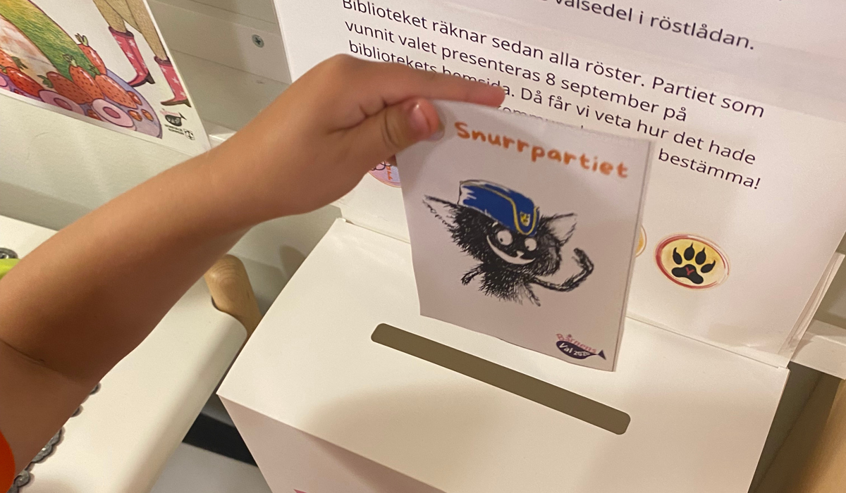 Ett barn röstar i barnens val på biblioteket.