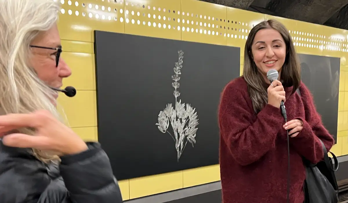 Jasmin med mikrofon bredvid konstguiden Marie på Fridhemsplans tunnelbanestation.