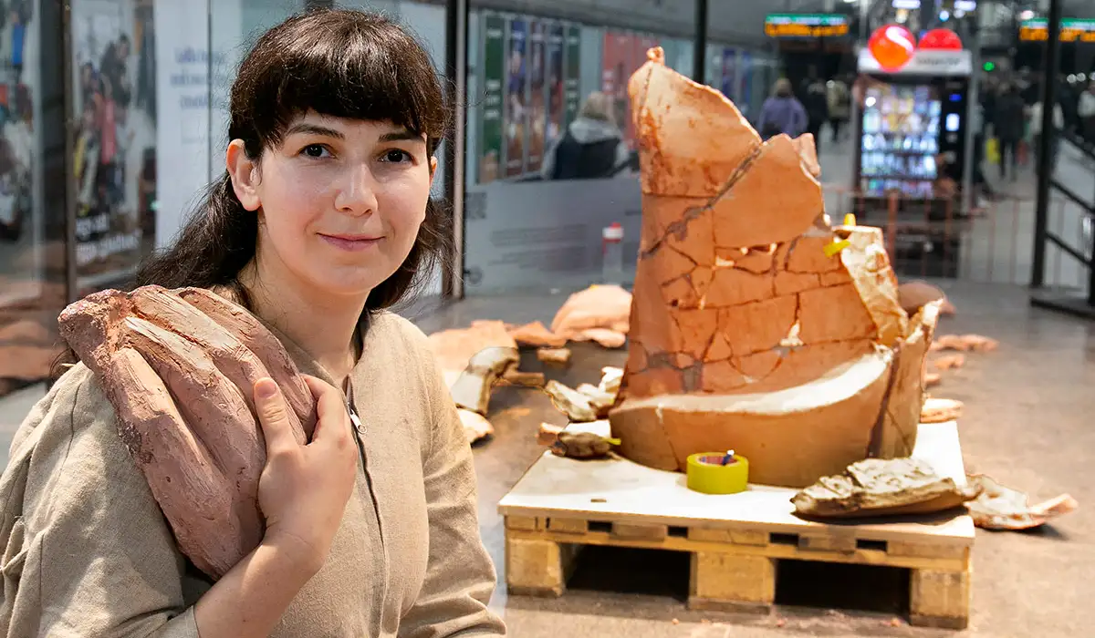 Nada i montern omgiven av keramiska skärvor i stort format.