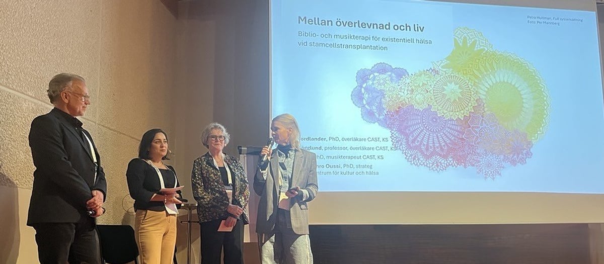 En grupp m&auml;nniskor som st&aring;r framf&ouml;r en projektorsk&auml;rm.