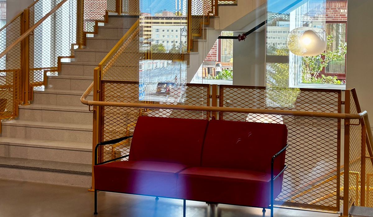 En röd soffa som står framför en trappa.