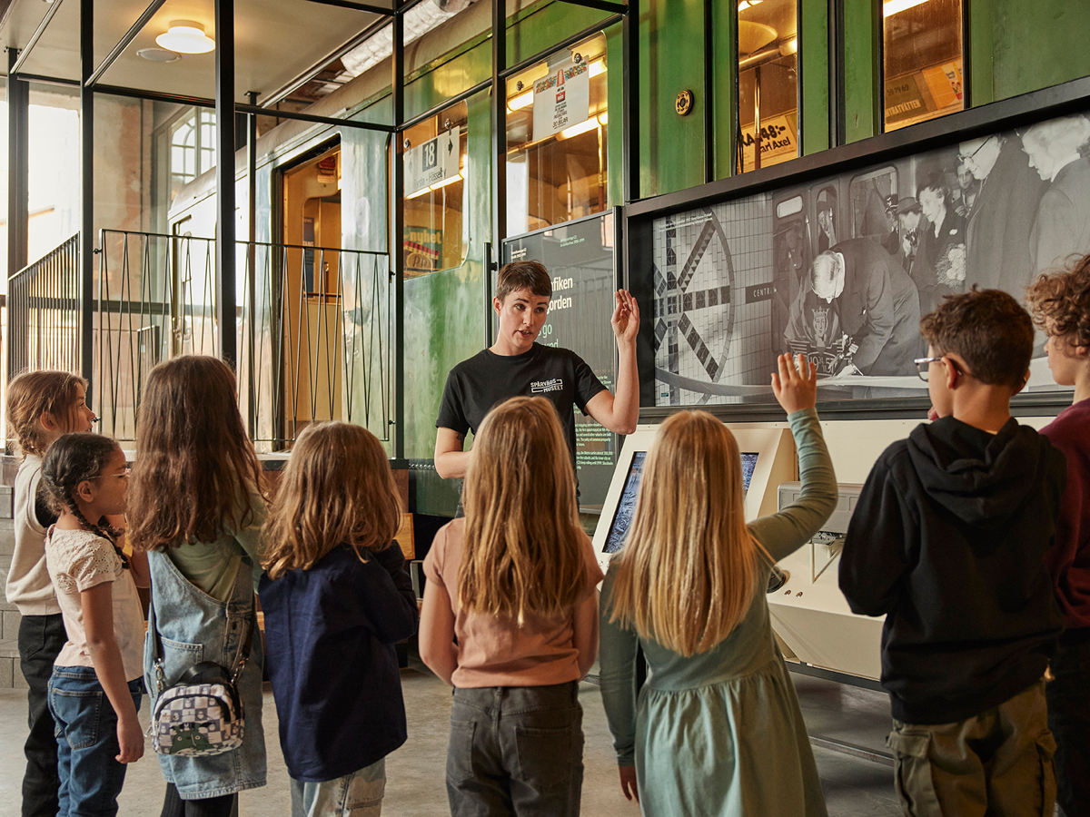 En museipedagog berättar visar språvägmuseet för barn