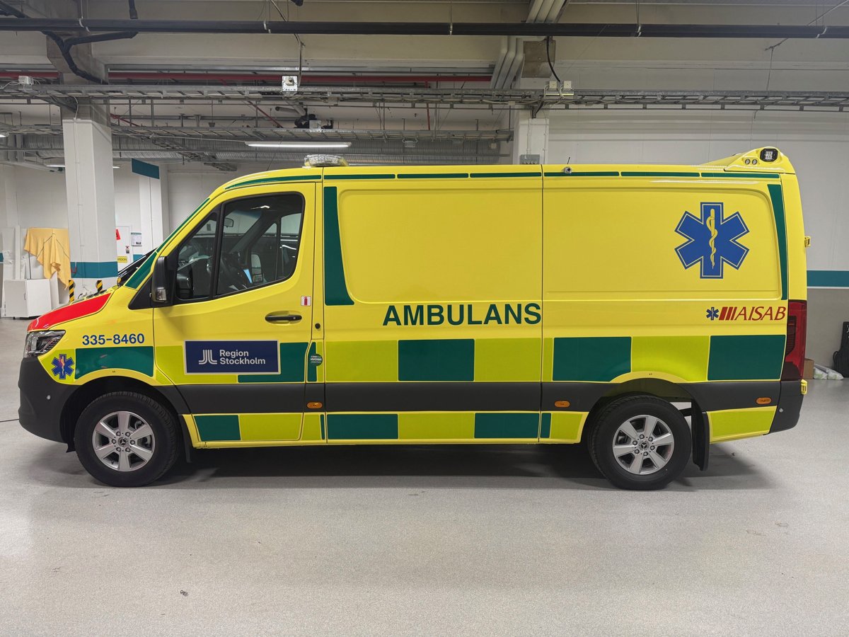 En gul ambulansbil parkerad i en byggnad.