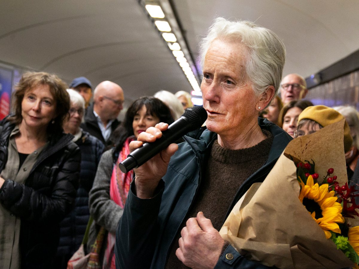 En kvinna håller i en blombukett och en mikrofon.