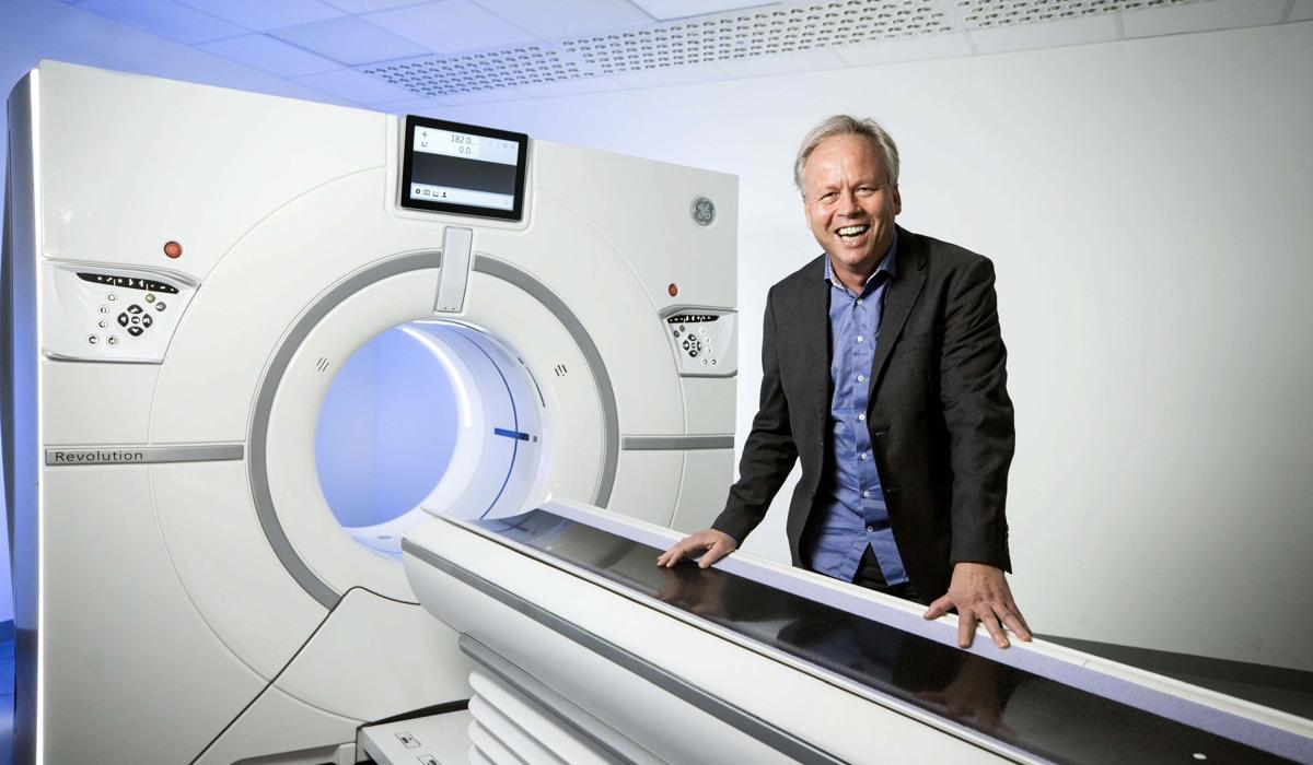 Foto på man som står vid en röntgenmaskin. 