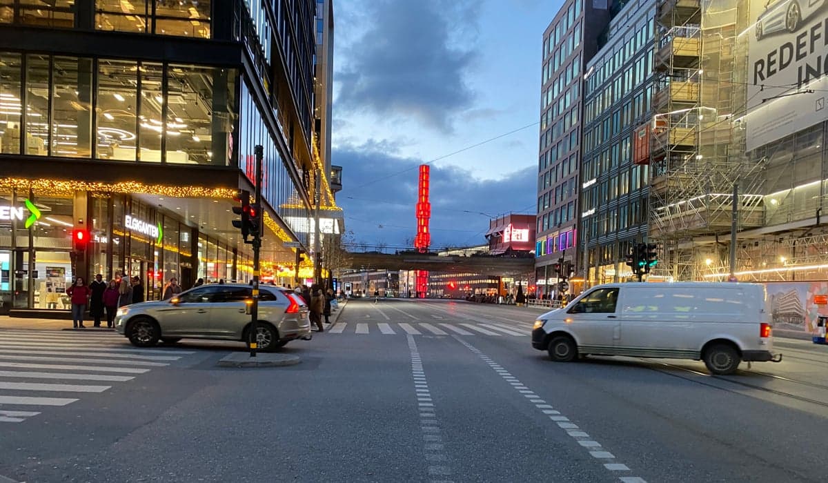 Två bilar svänger av från Hamngatan i kvällsljus