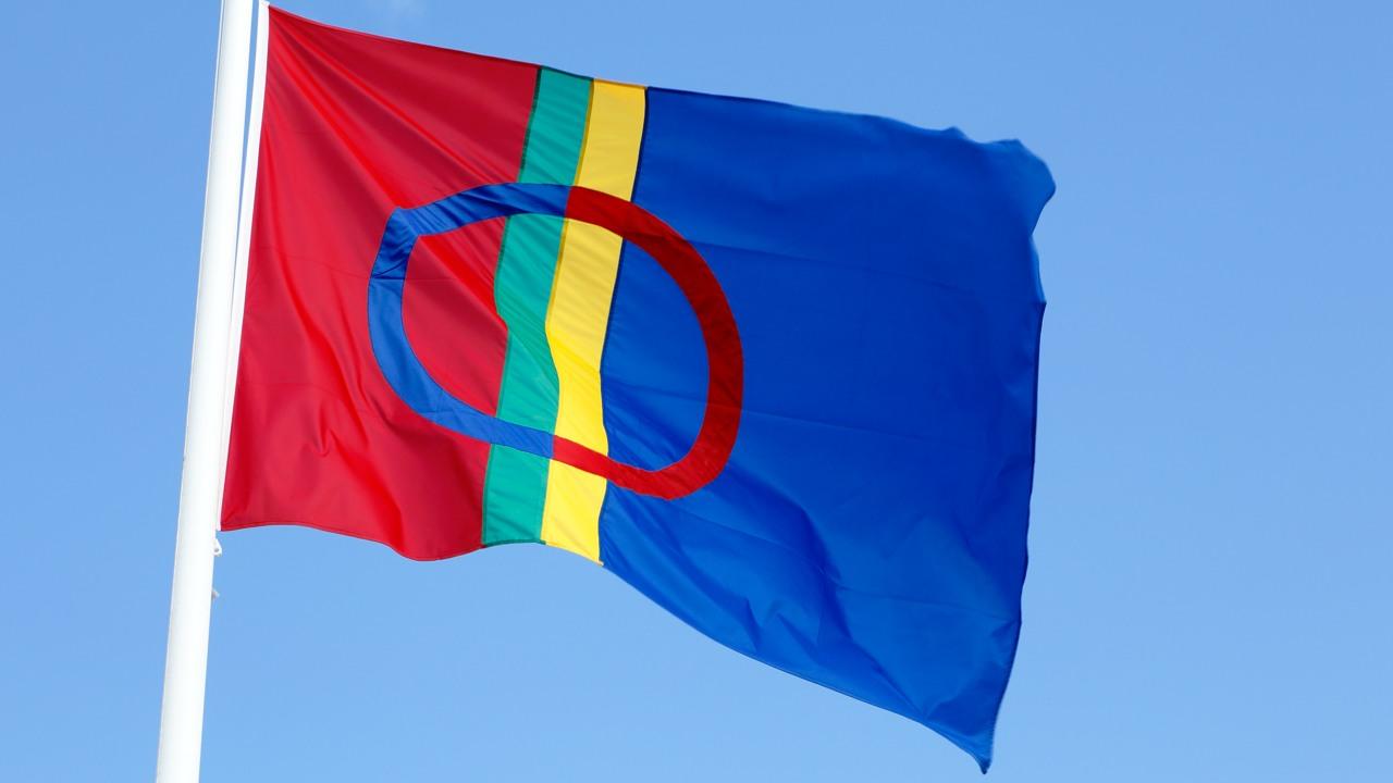 Den samiska flaggan mot blå himmel i färgerna röd, grön, gul och blå.