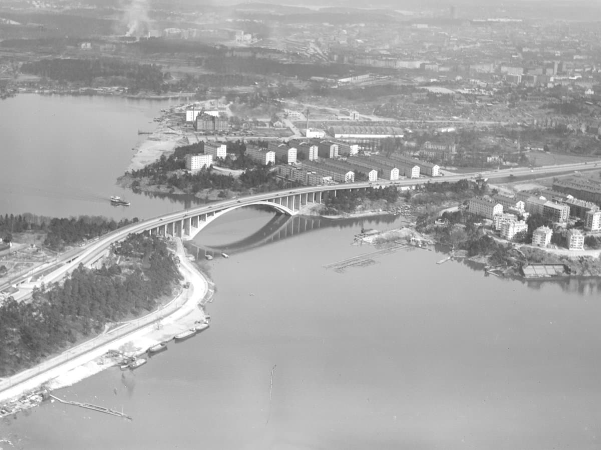 Flygfoto över en stadsmiljö. I mitten syns en bro över vatten mellan två öar. 
