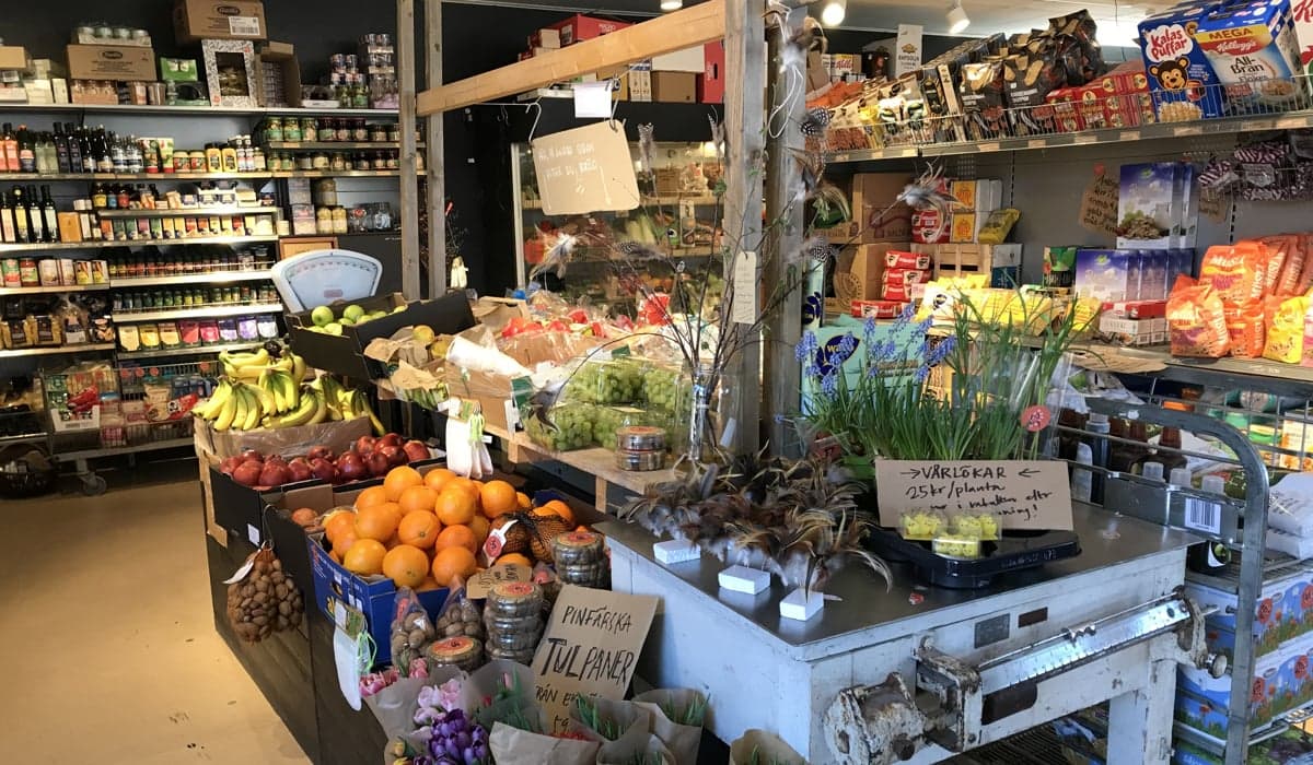 Bild från skärgårdshandel. Välfylld butik med frukt och grönt samt konserver.