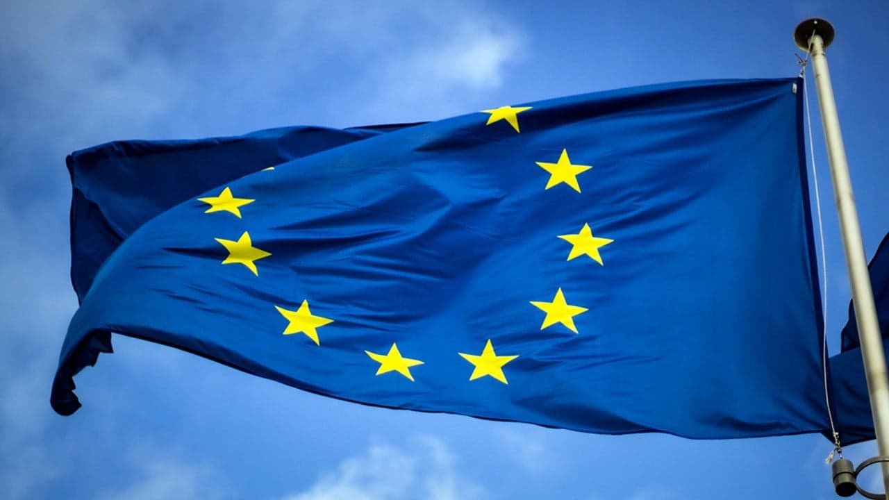 En EU-flagga vajrar med blå himmel i bakgrunden