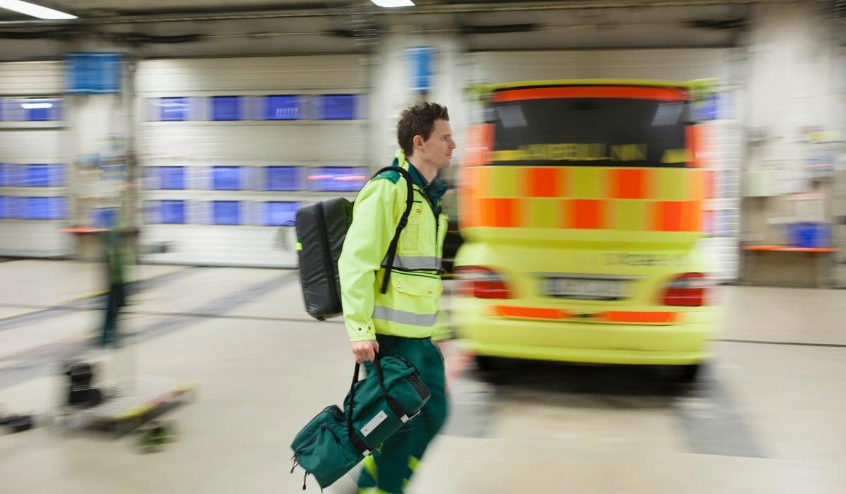 Ambulanssjuksköterska på väg till ambulansen
