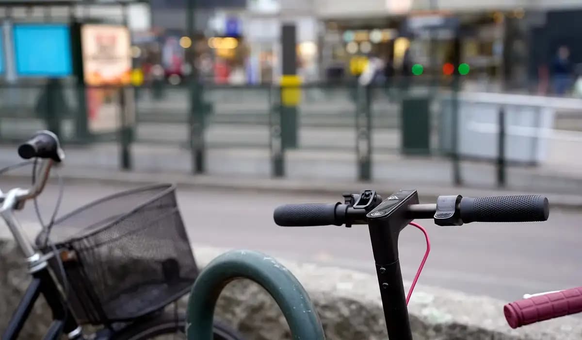 Cykel och elsparkcykel står parkerad i anslutning till hållplats på tvärbanan.