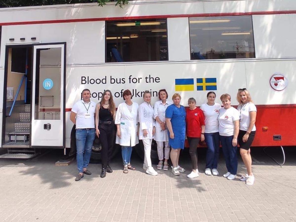 Foto på vårdpersonal som står uppradade utanför blodbussen.