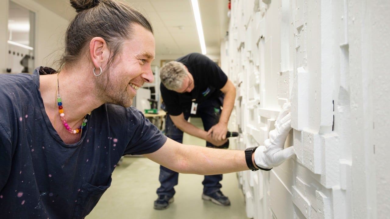 Konstnärer och tekniker bygger på en vägg.