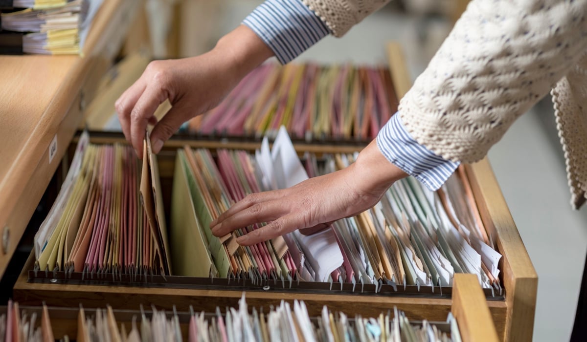 Person letar efter dokument i ett arkiv