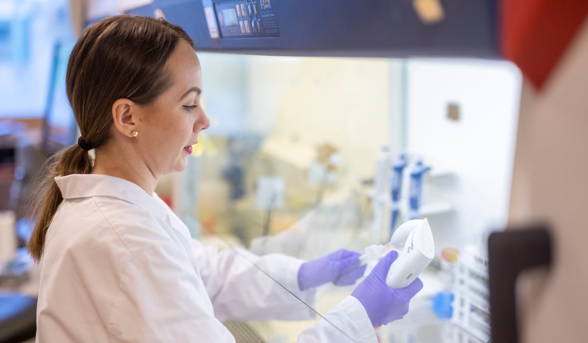 Kvinna i labbkläder som arbetar i ett laboratorium