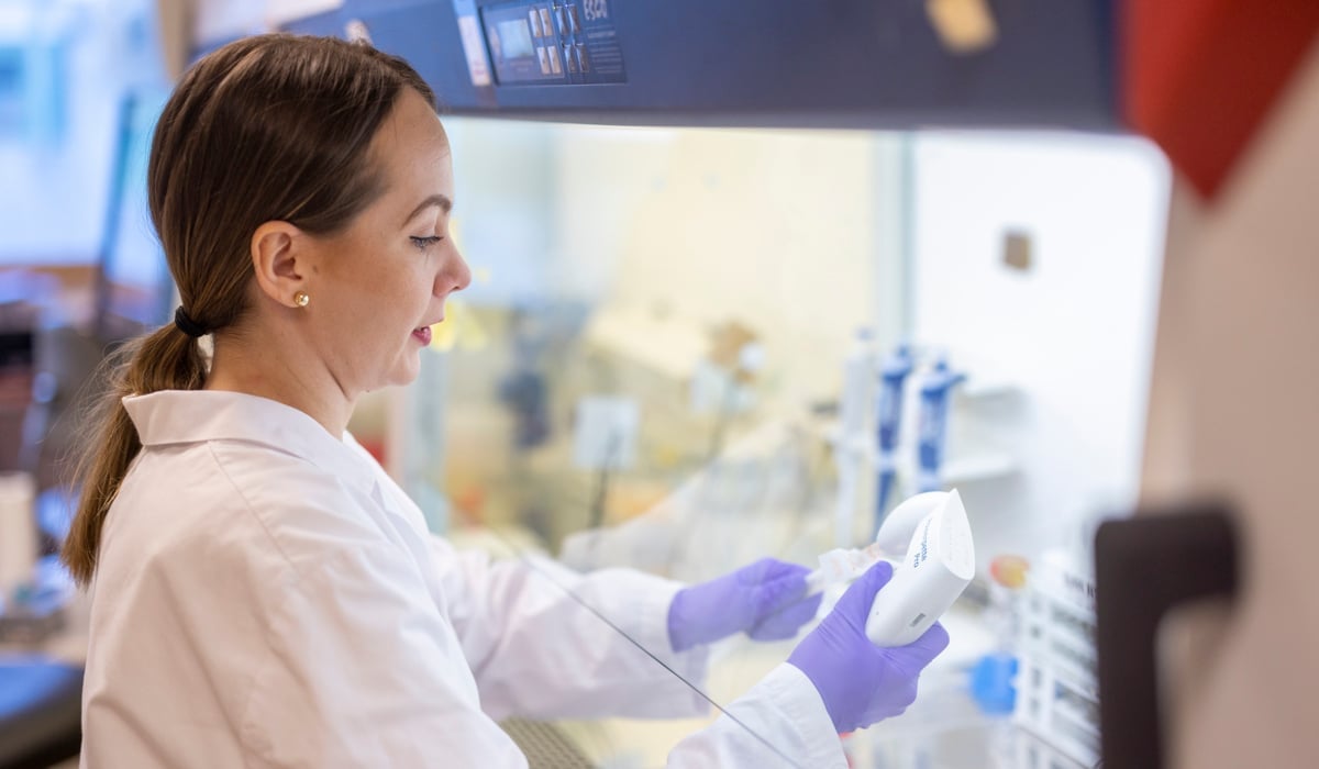 Kvinna i labbkläder som arbetar i ett laboratorium