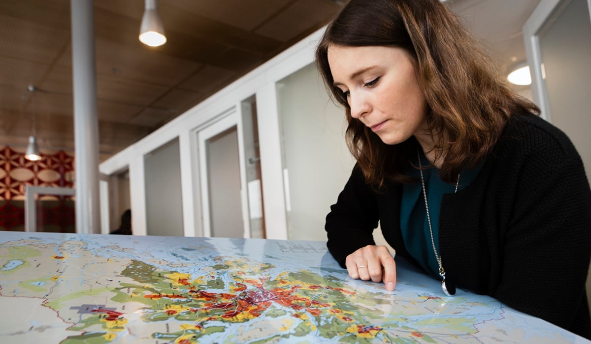Kvinna kollar på karta över Stockholms län