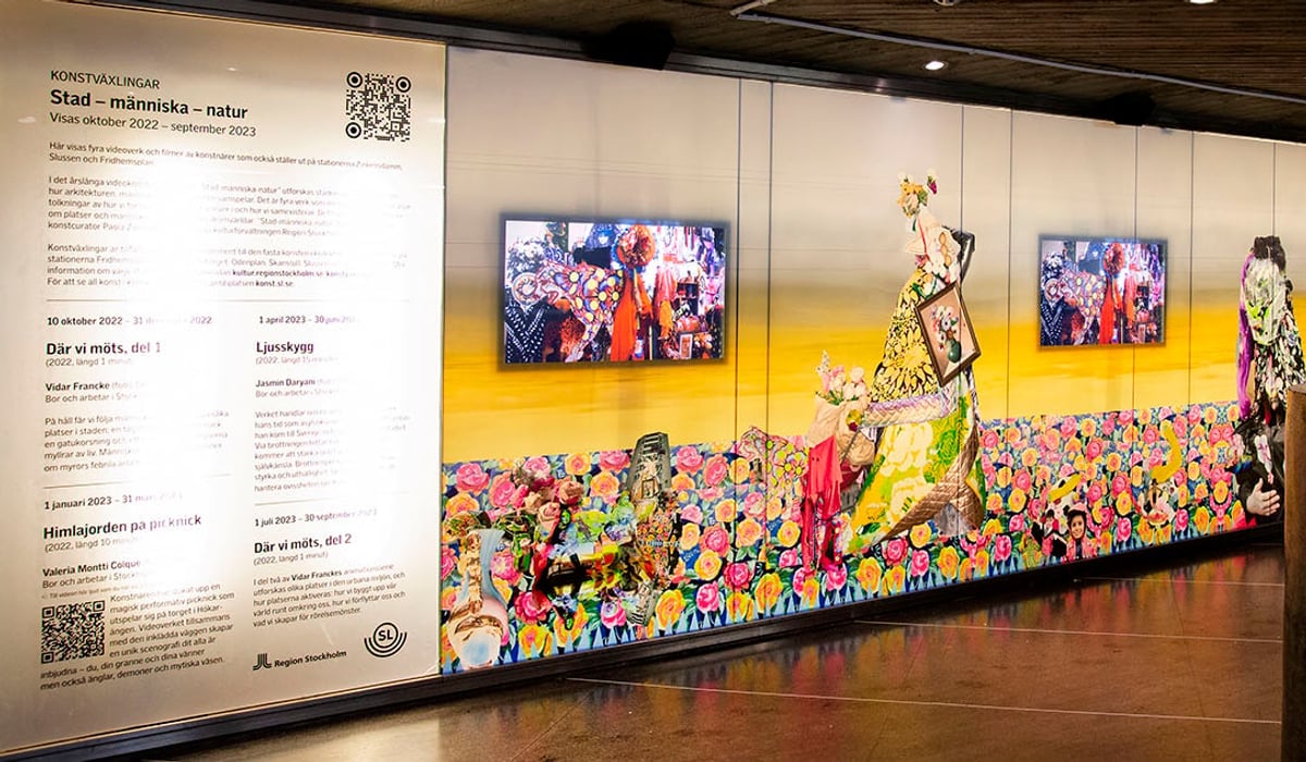 Stationsvägg vid Skanstull där det visas videokonst på fyra skärmar.