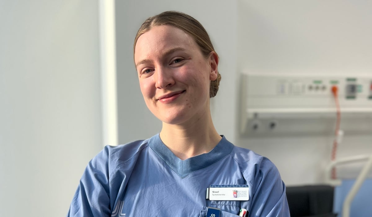 En kvinna i operationskläder står i ett sjukhusrum.