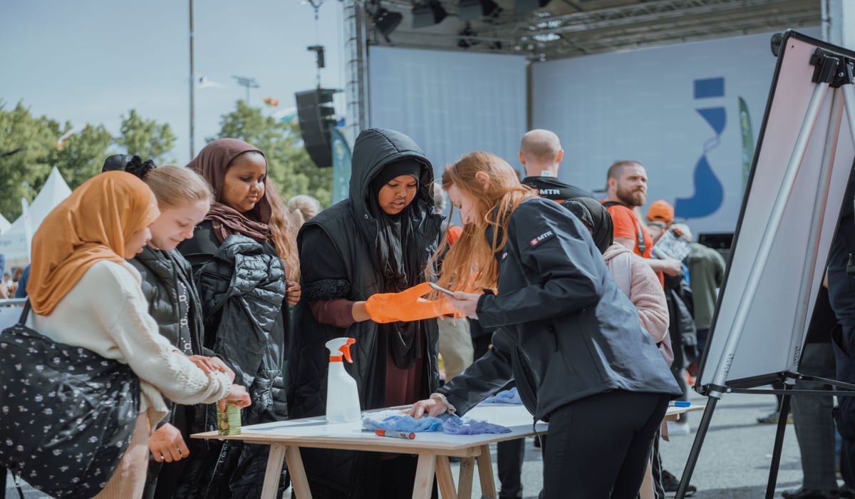 Fyra ungdomar samtalar med representanter från MTR under Järvaveckan. 