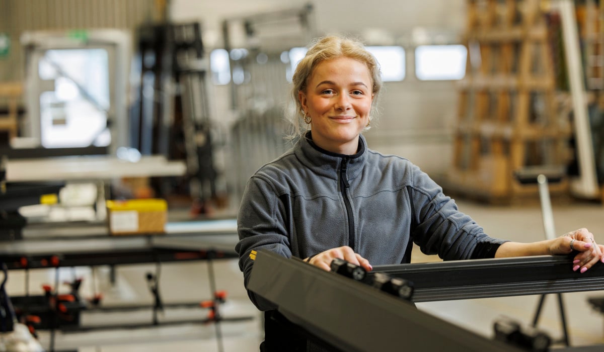 En kvinna står framför en maskin i en fabrik.