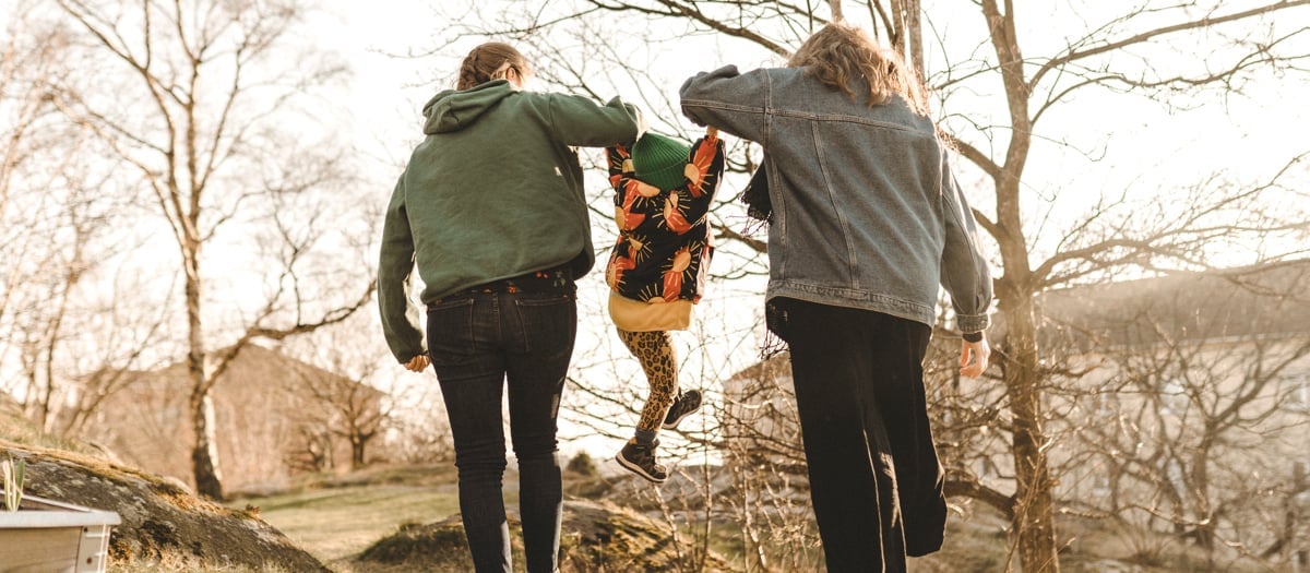 Två vuxna lyfter upp sitt barn emellan dom