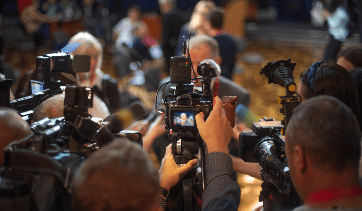 Journalister och fotografer intervjuar person