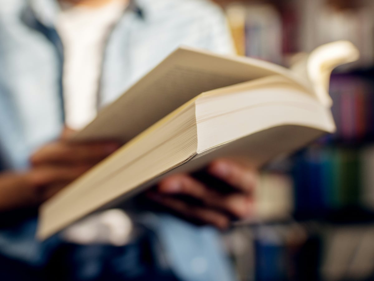 Händer som håller i en bok i närbild